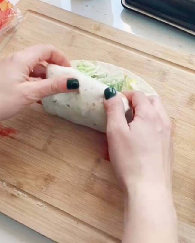 The TikTok user then folds the wrap from the bottom before cutting in half (Credit: TikTok/@thefoldinglady)