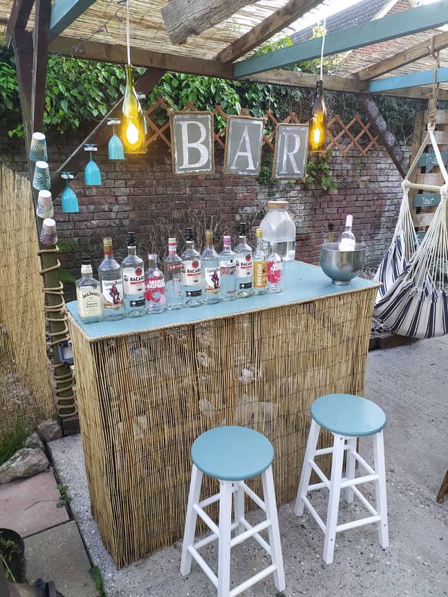 The bar is installed, complete with bamboo fencing and plenty of drinks options! (Credit: Caters)